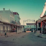 Main street of El Rocio in Andalusia, lined with white houses and traditional shops, calm atmosphere in winter with no visible human presence.
