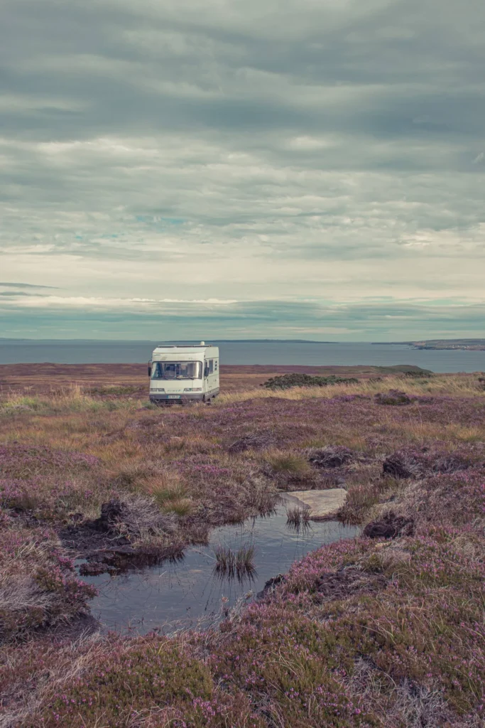 Motorhome parked in the middle of a Scottish moor with a view of the sea