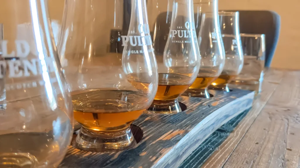 Old Pulteney Whisky-Verkostung mit Gläsern auf einem Holztisch in der Brennerei in Wick, Schottland, Sommer.