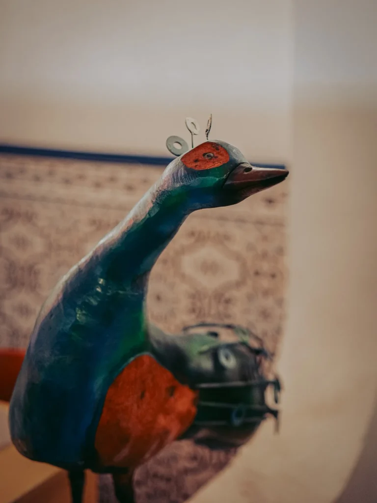 Colourful bird sculpture against a patterned wall inside Nikita restaurant in Tavira, Algarve