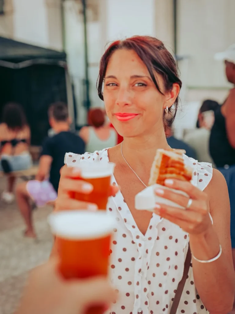 Caroline with a beer and a sandwich during the São João in Tavira