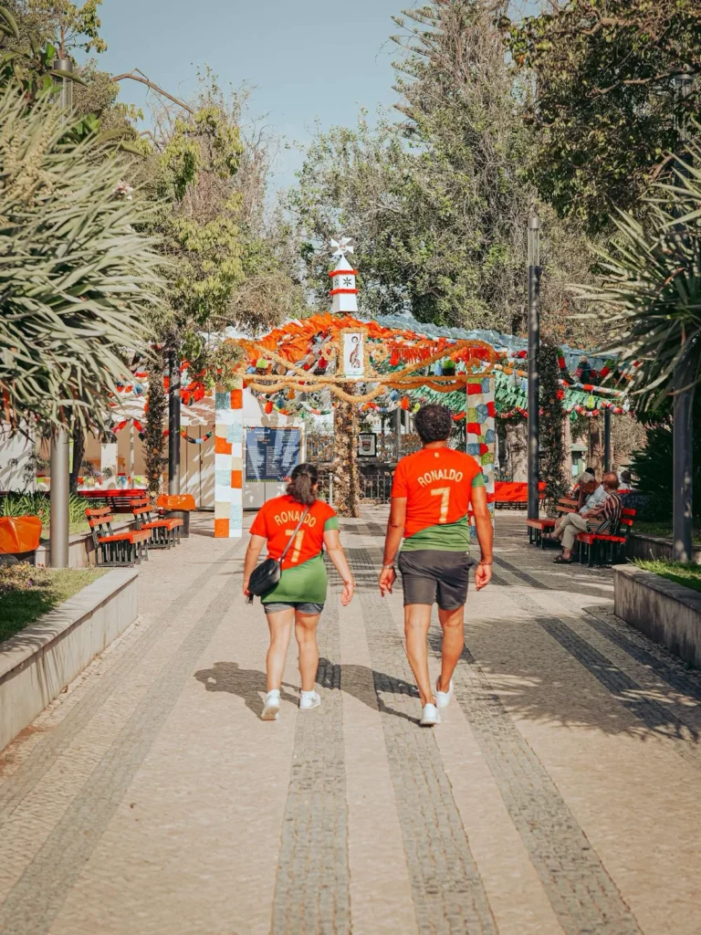 Couple in Ronaldo jersey from Portugal in a street decorated in Tavira for São João