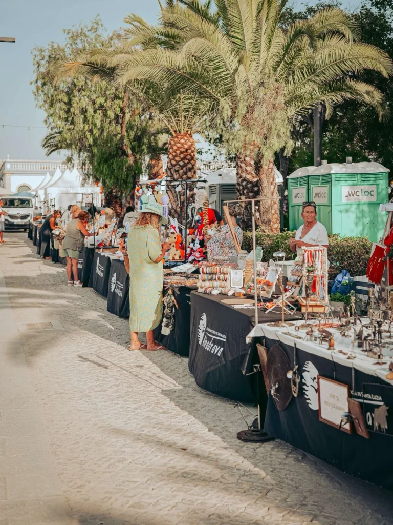 Craft stalls under the palm trees during São João in Tavira
