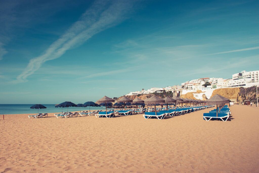 Albufeira beach with golden cliffs and straw umbrellas