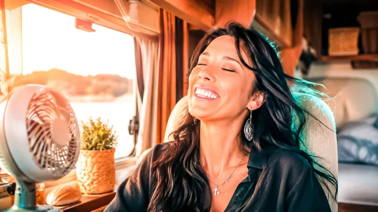 Caroline enjoying a breeze in front of a fan in the camper van, camper van air conditioning guide