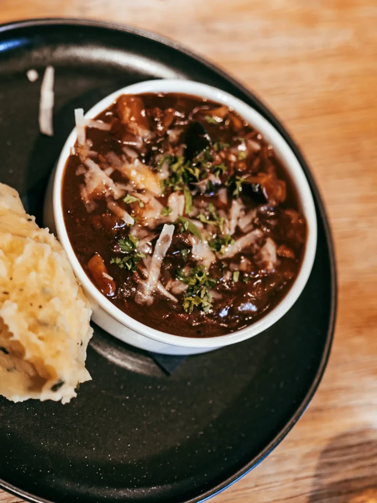 Hot dish served at the Allan Park Hotel restaurant in Stirling, consisting of a saucy stew garnished with fresh herbs and mashed potatoes, presented on a black plate in August 2026.