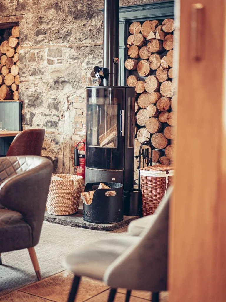 Modern wood stove in the restaurant area of the Allan Park Hotel in Stirling, with stacked logs and a cozy atmosphere in Scotland in mid-August 2026.