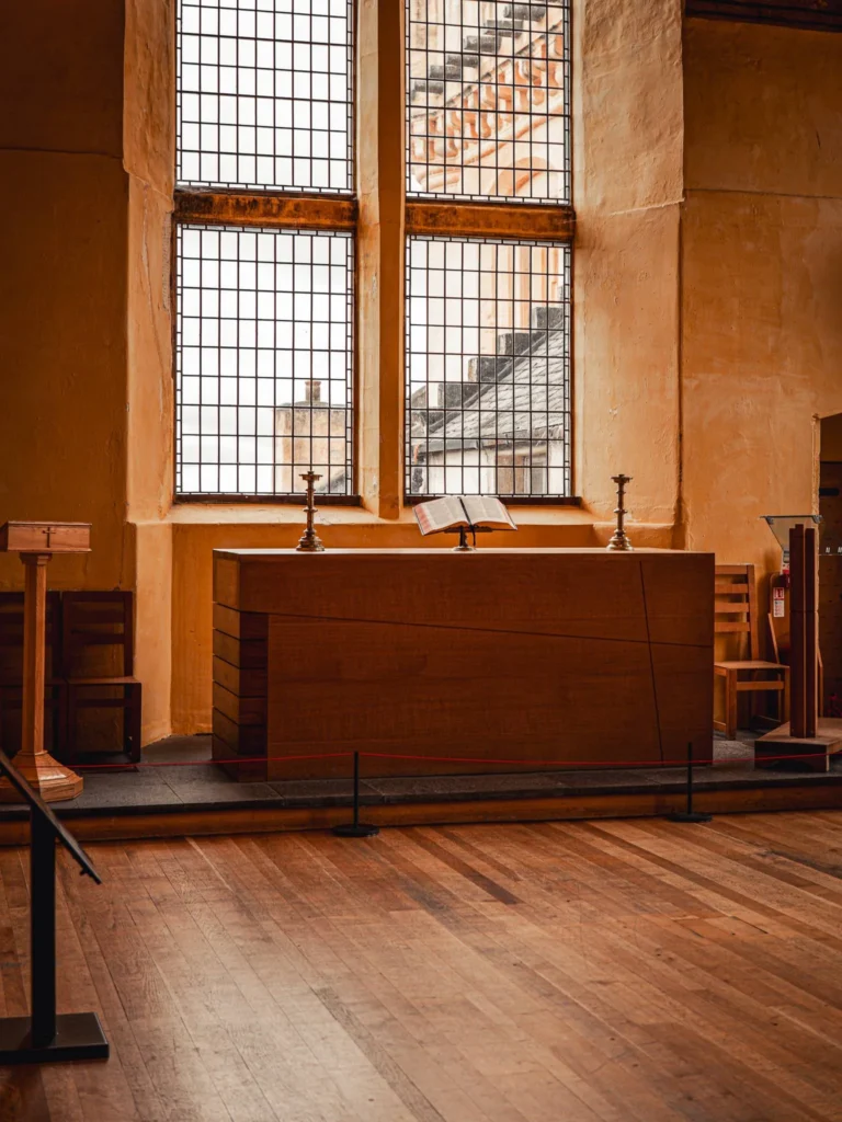The wooden altar beneath the tall leaded windows of the Chapel Royal, on the Inner Close at Stirling Castle.