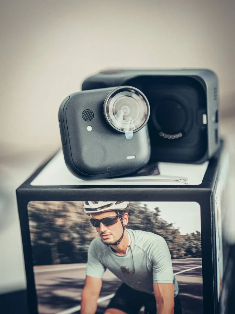 Das Kameramodul der Insta360 GO Ultra vor seinem Action Pod, die magnetische Aufnahme des Gehäuses gut sichtbar.