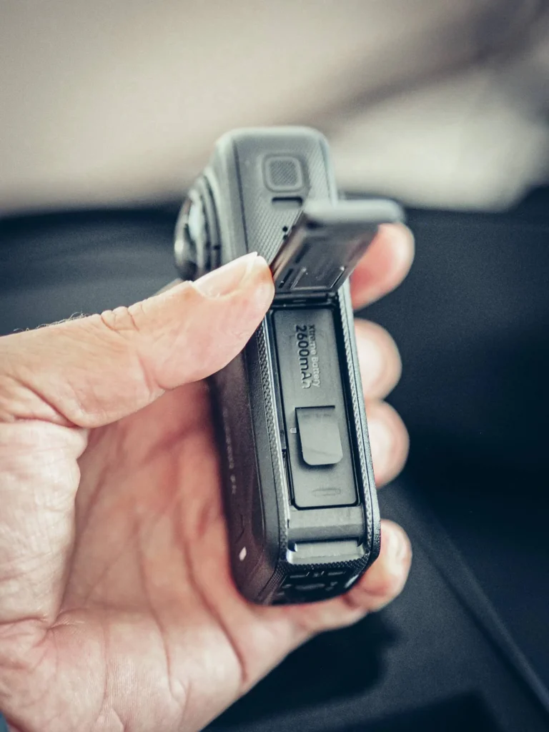 Battery compartment of the Insta360 X6 open, Xtreme 2600 mAh battery visible