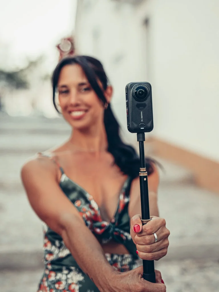 Caroline holds the Insta360 X6 on her pole in a cobbled alley in Lagos