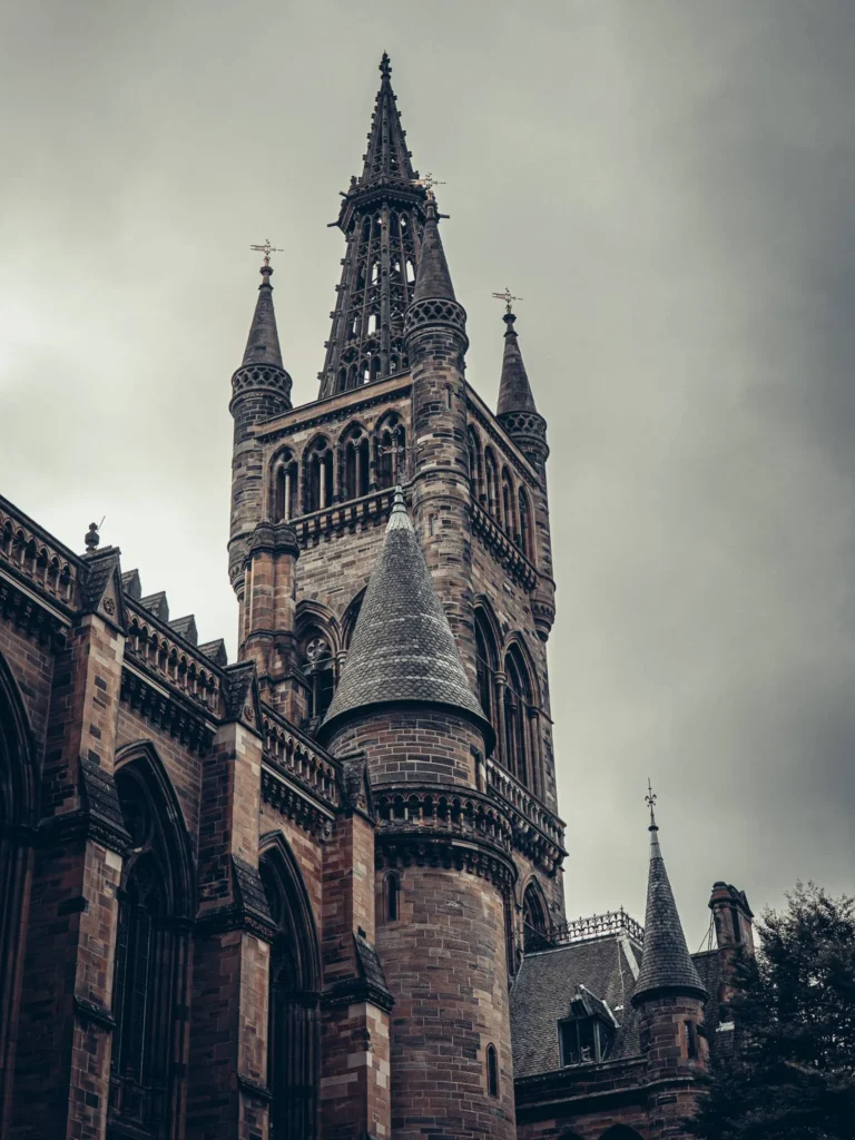 Tour of the Main Building of the University of Glasgow. From a distance, it can easily be mistaken for a bell tower: the neo-Gothic architecture recalls both a cathedral and a university, which strikes Xavier during this visit in August 2026.