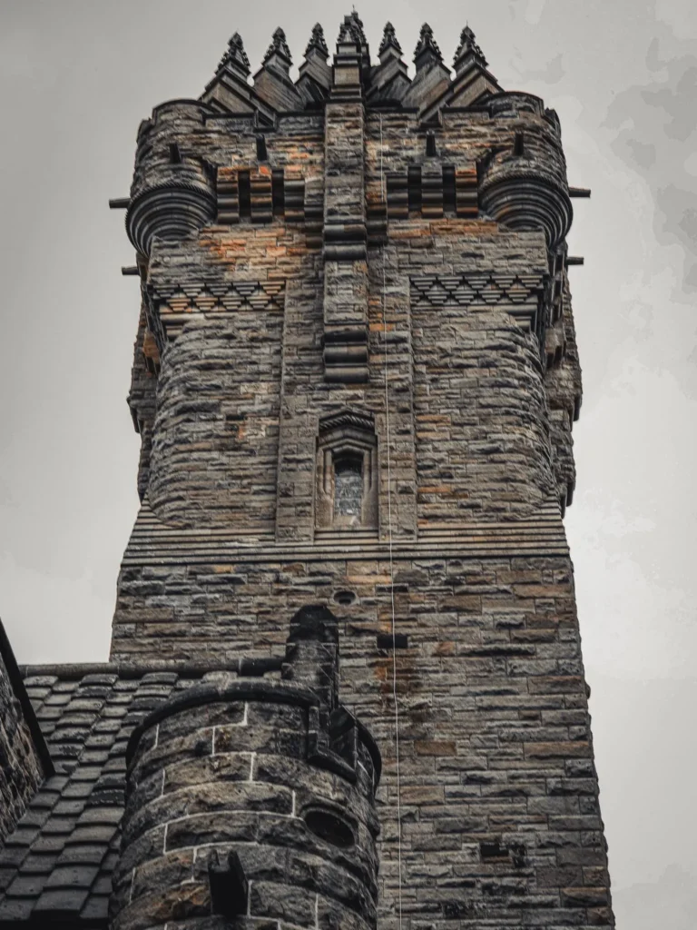 The stone tower of the Wallace Monument in Stirling, Scotland, photographed from below under a grey sky on 17 August 2026.