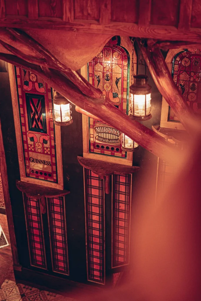 Coloured stained glass and lanterns on a staircase at Waxy O'Connor's pub in Glasgow.