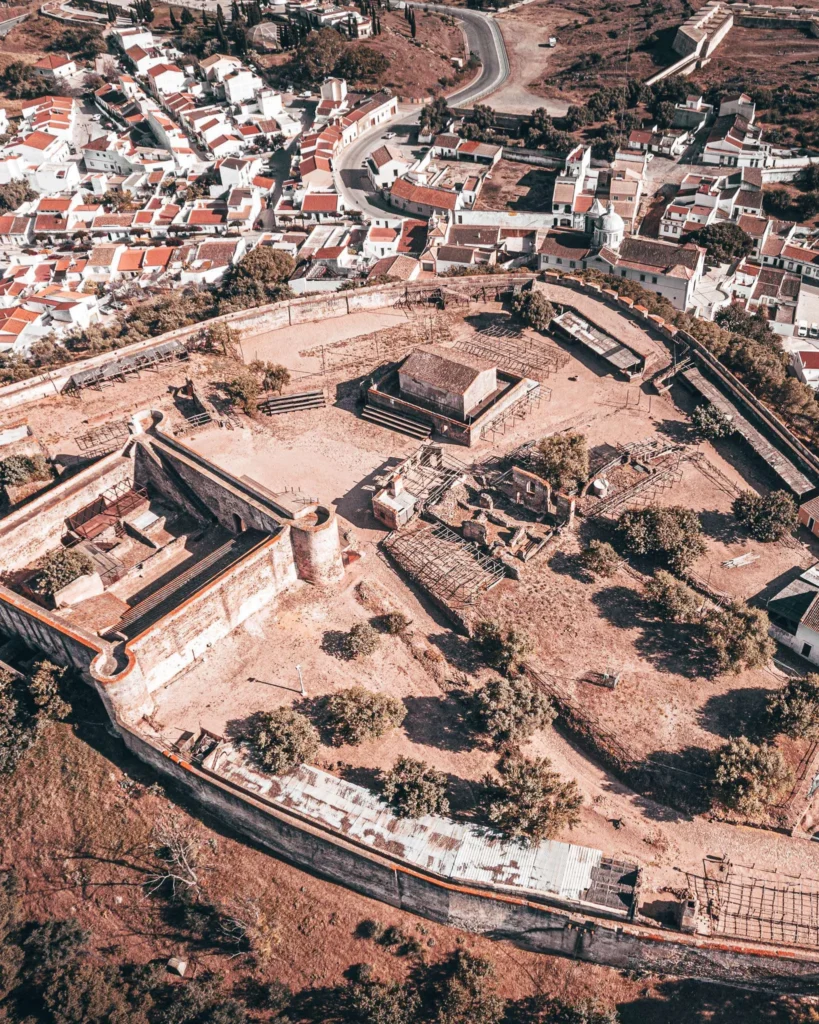 Aerial view of a historic fortress surrounded by ramparts in Castro Marim, Algarve, with the village of red roofs in the background, taken in spring 2024.