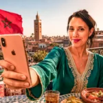 Caroline in Marrakesch mit einer unbegrenzten SIM-Karte vor der Koutoubia-Moschee, marokkanische Flagge im Hintergrund.