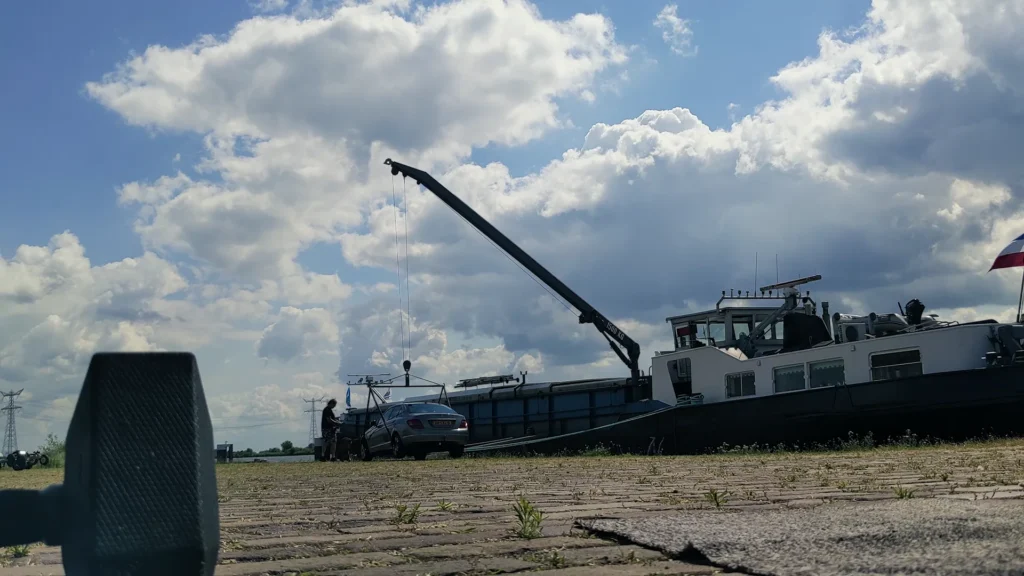 Ein Auto wird in Ramspol mit einem Kran auf einen Lastkahn gehoben