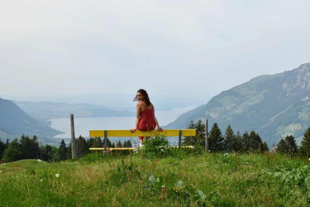 Caroline auf der gelben Bank mit Seeblick im Gebiet Urmiberg